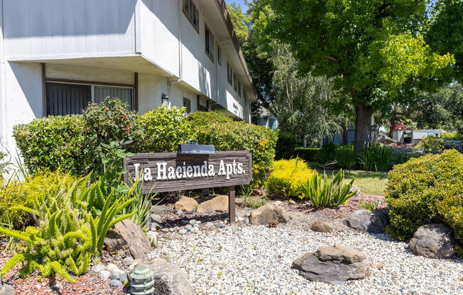 a sign in a garden in front of a building