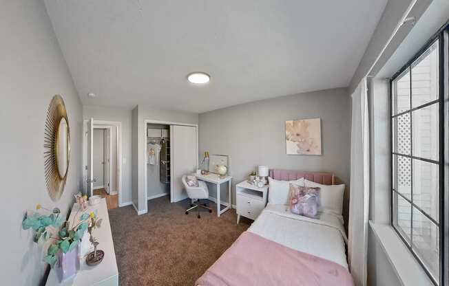 a bedroom with a bed and a desk and a window
