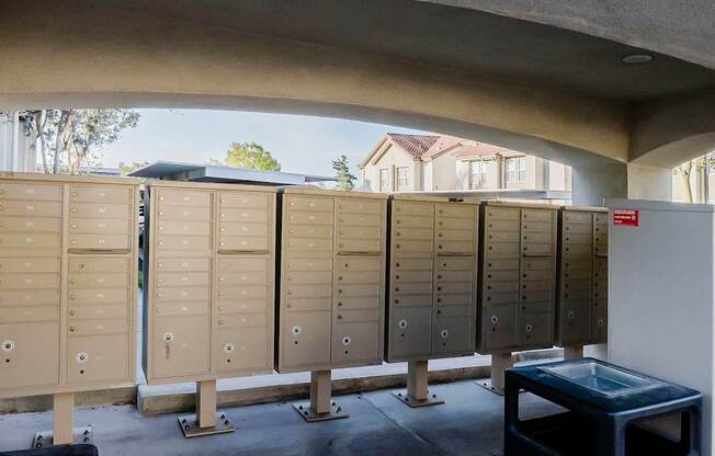 A row of lockers in a room with a table in front.