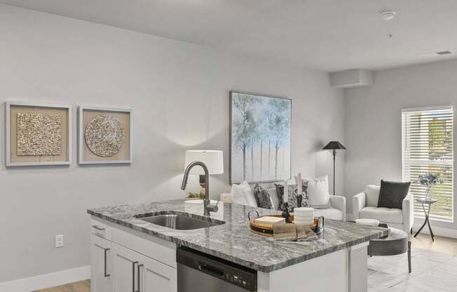 A modern kitchen with a marble countertop and white cabinets.