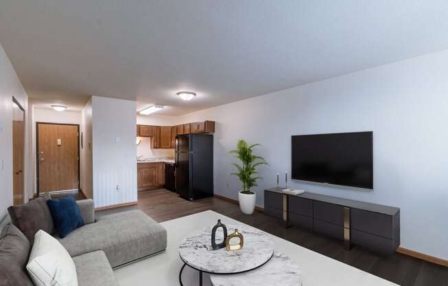 a living room with a tv and a kitchen. Moorhead, MN South Park Apartments