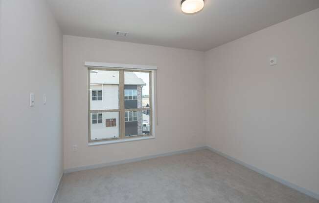 a bedroom with a large window and white walls at The Crossings at Windsong, Prescott Valley