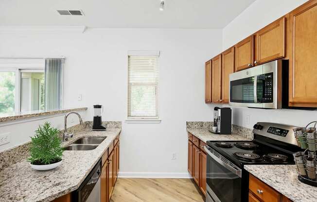 A kitchen with wooden cabinets and granite countertops.