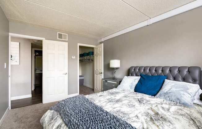 A bedroom with a bed, nightstand, and a lamp.