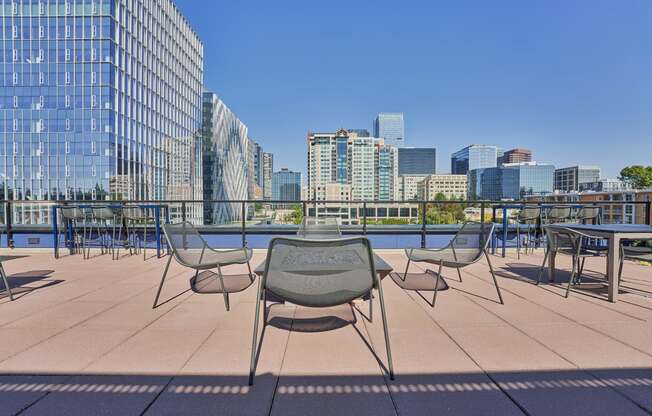 a rooftop patio with tables and chairs and a view of the city