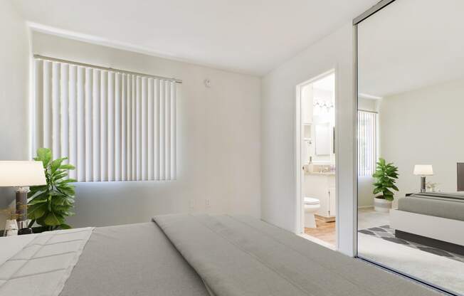 a white bedroom with a bed and a bathroom