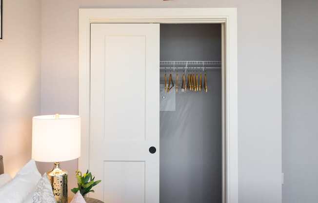 a bedroom with a bed and a closet with a door open