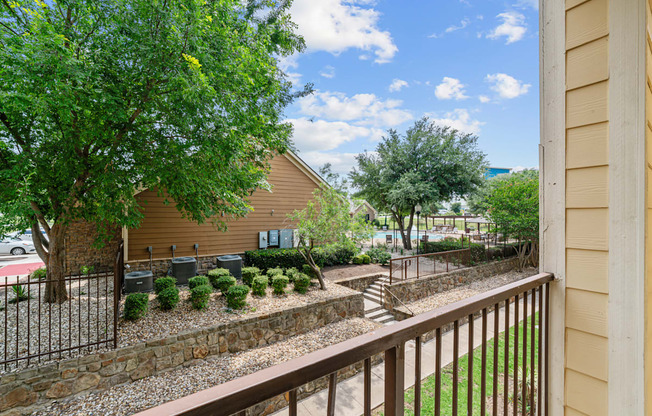 A house with a brown fence and a green tree.