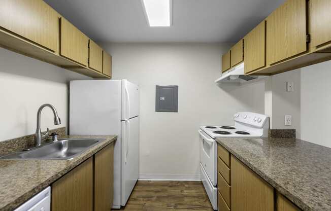 a kitchen with a white refrigerator next to a stove top oven at Willows Court Apartment Homes, Seattle, Washington 98125