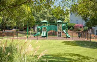 A playground with a green slide and a green canopy.