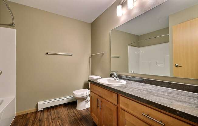 a bathroom with sink toilet and mirror. Fargo, ND Urban Plains Apartments