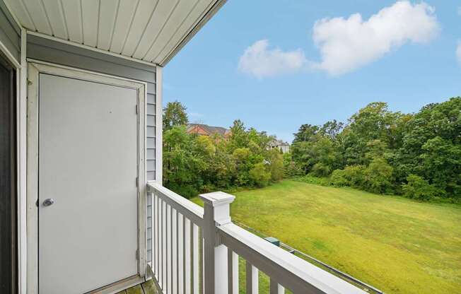 the view from the balcony of a home overlooking a grassy field and a door at ReNew Odenton