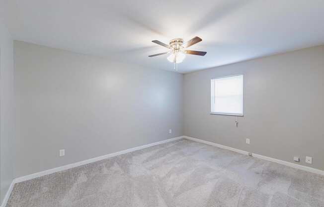 a bedroom with a ceiling fan and a window