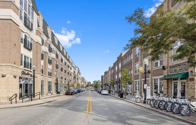 a city street with tall buildings and bicycles parked on the sidewalk