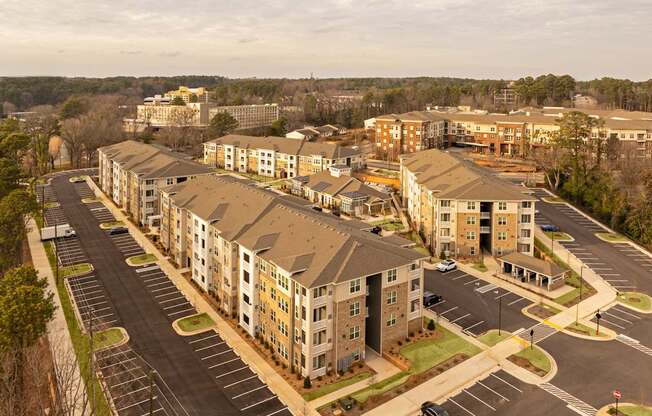 A large apartment complex with a parking lot in front.