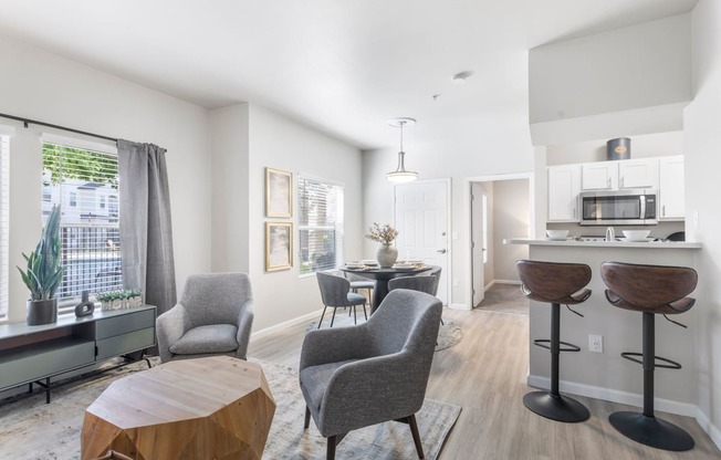 a living room with a table and chairs and a kitchen