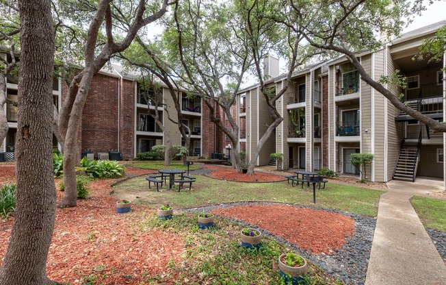 A courtyard with a picnic table surrounded by apartment buildings.