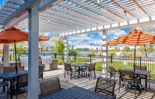 A patio with tables and chairs under a white pergola.