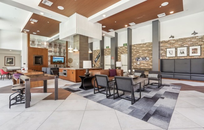 a large lobby with tables and chairs and a reception area