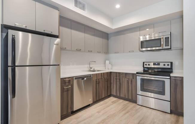 A modern kitchen with stainless steel appliances and wooden cabinets.