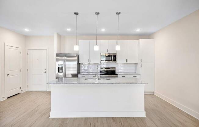 A modern kitchen with a white countertop and stainless steel appliances.
