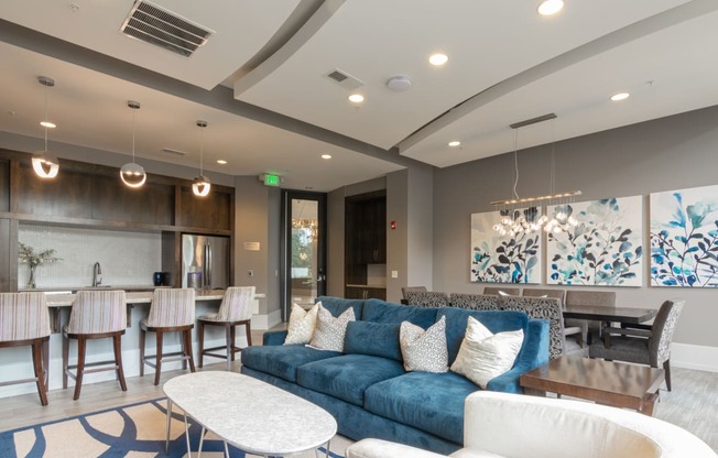 a living room with a blue couch and a table and chairs