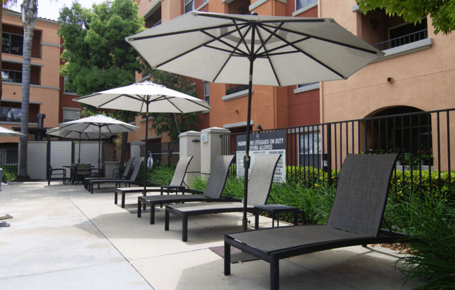 A patio with chairs and umbrellas.