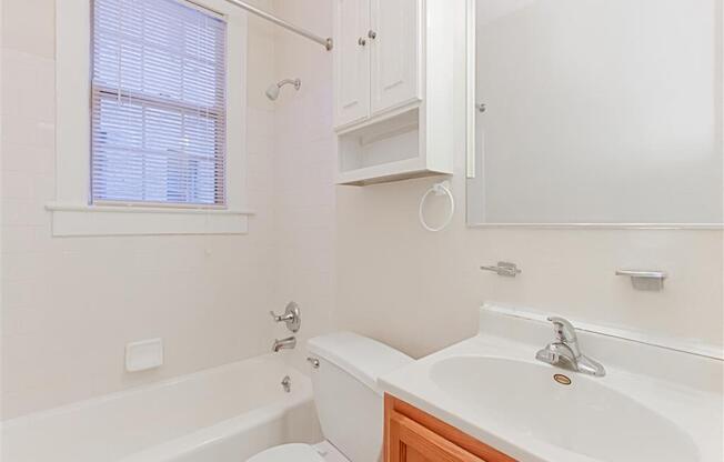 bathroom with tub, vanity, toilet and window at parkside apartments in washington dc