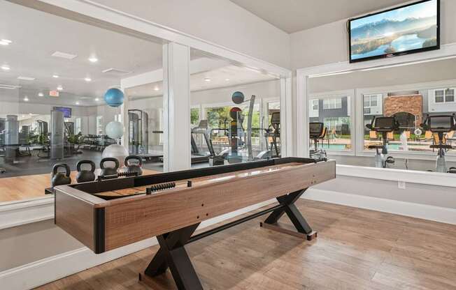 A room with a pool table and a television mounted on the wall.