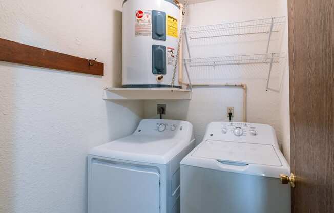 two washers and a dryer in a laundry room. Fargo, ND Plumtree Apartments