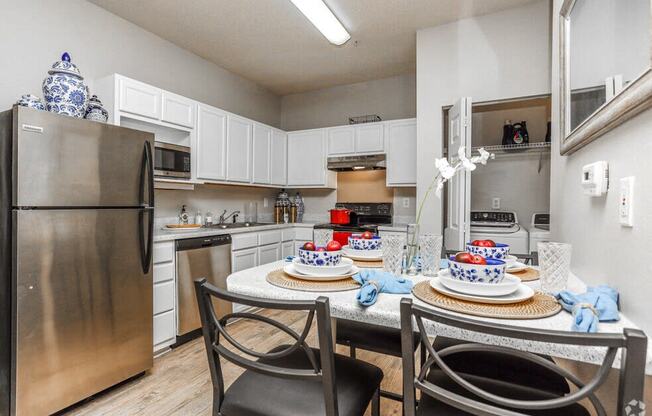 a kitchen with stainless steel appliances and a dining room table