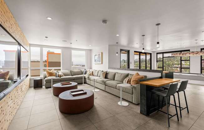 A modern living room with a long couch, a coffee table, and a dining table.