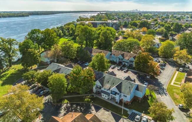 an aerial view of a neighborhood of houses with a river in the background