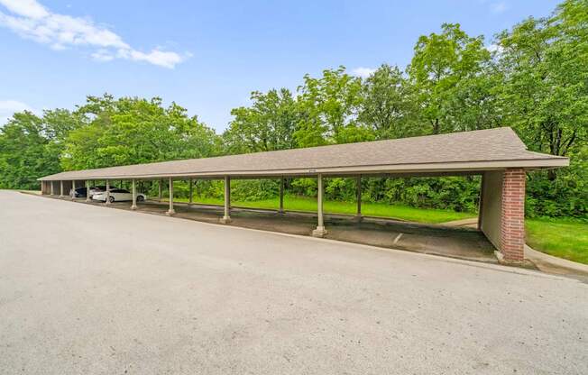 A long covered parking area with a brick pillar.
