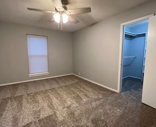 an empty room with a ceiling fan and a closet