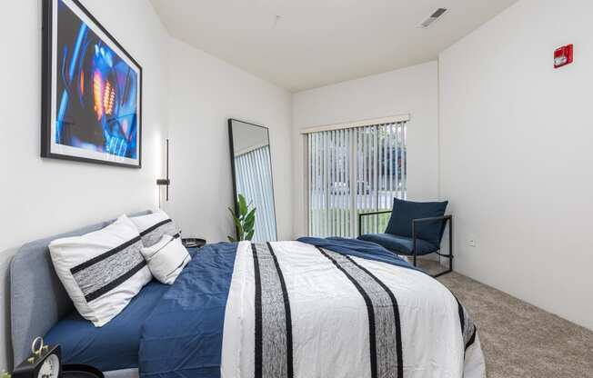 a bedroom with a blue and white bed and a chair  at Shoreline Village, Richland