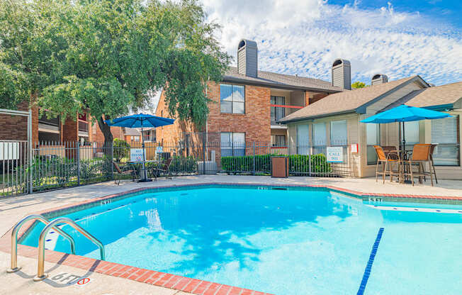 A swimming pool surrounded by a fence and trees.