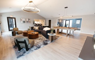 a large living room with a pool table and couches