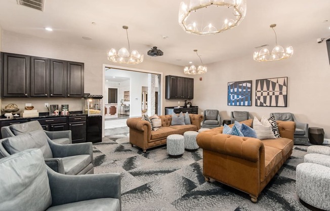 A living room with a brown sofa and grey armchairs.