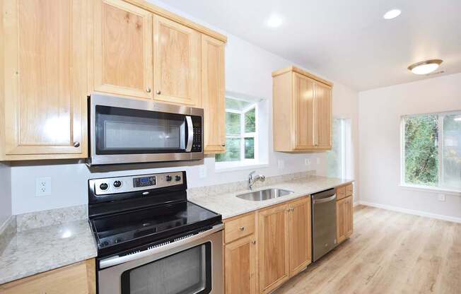 A kitchen with wooden cabinets and a stainless steel oven.