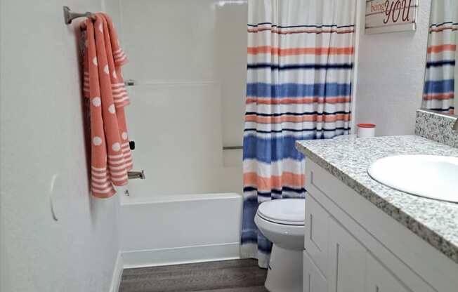 A white bathroom with a towel hanging on the wall.