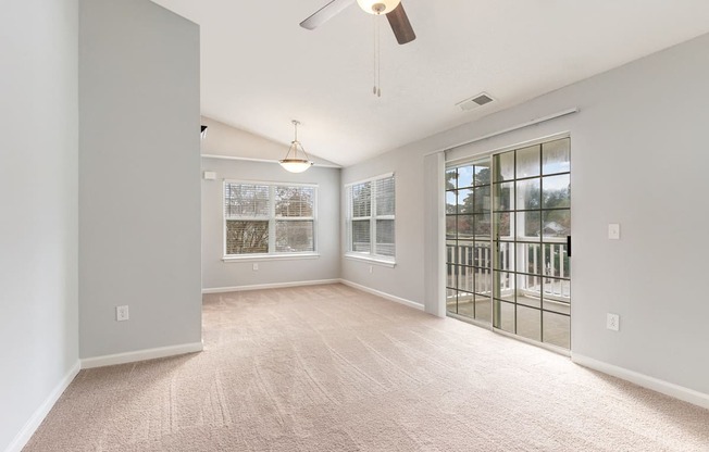 an empty living room with a door to a balcony