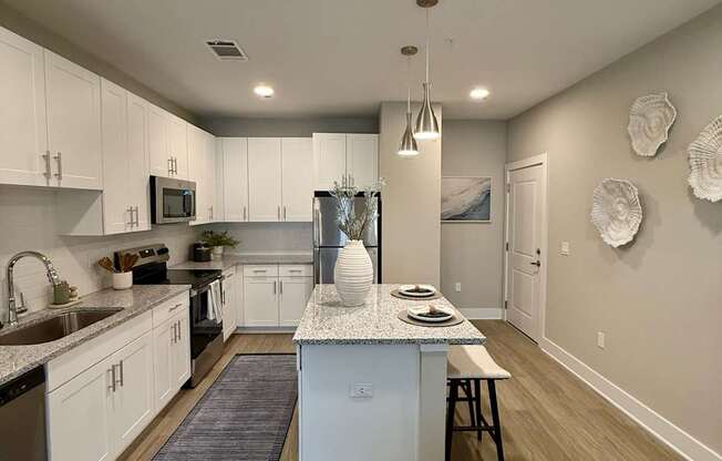 A modern kitchen with white cabinets and a center island.