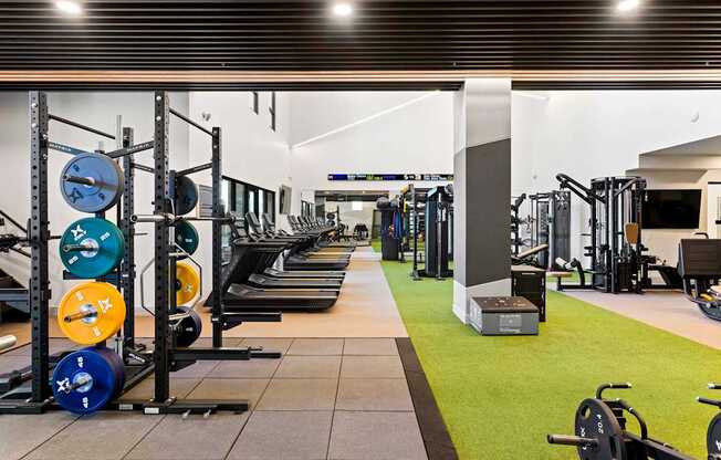 A gym with a variety of weightlifting equipment.