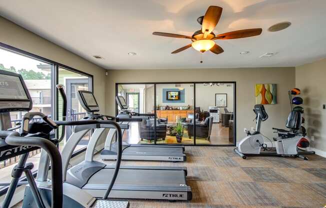 a home gym with exercise equipment and a ceiling fan