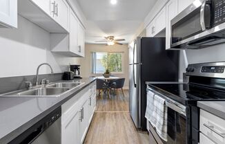 a kitchen with white cabinets and black appliances