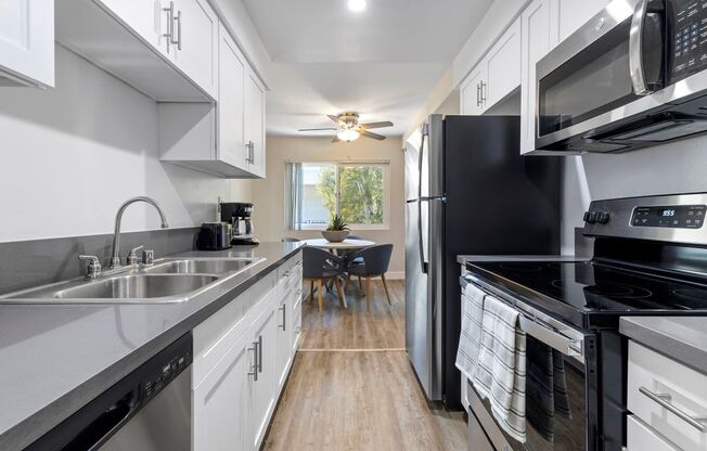 a kitchen with white cabinets and black appliances