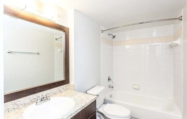 A white toilet sits next to a white sink in a bathroom.