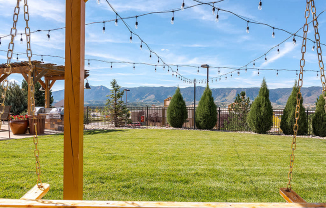 A swing set with a view of the mountains in the background.