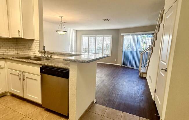 an open kitchen and living room with a stairway to a balcony